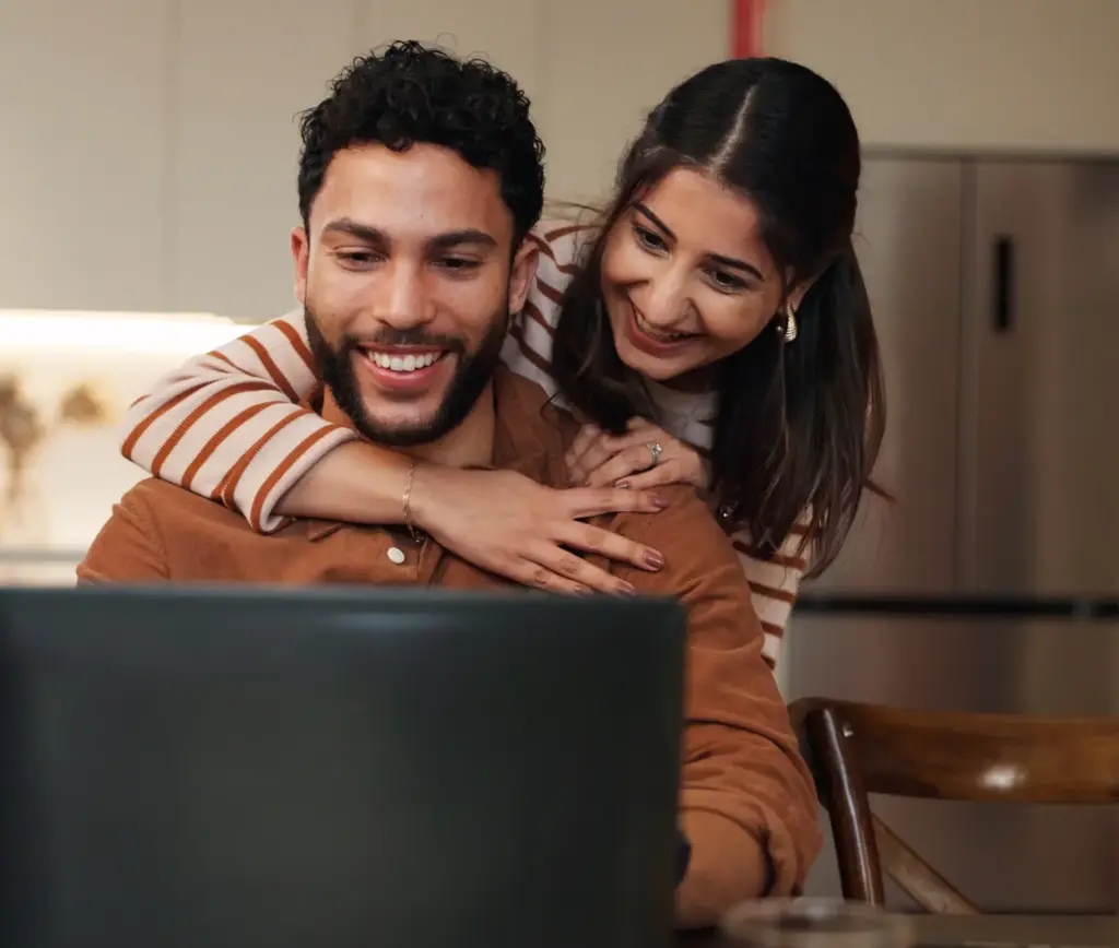 Couple looking at a laptop screen - buy-to-let mortgage advice at Futures Assured