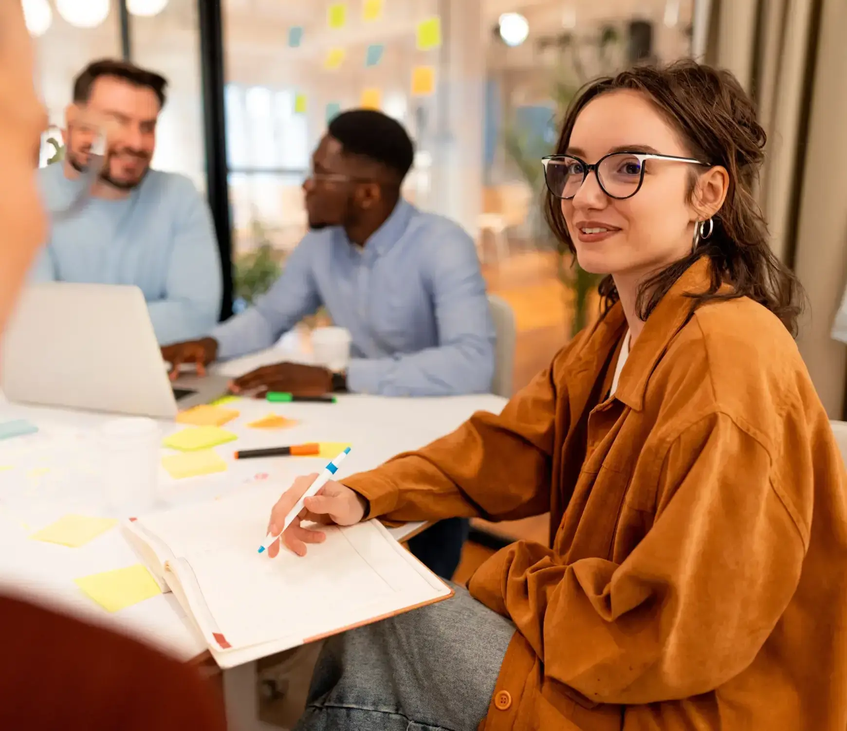 Young woman writing in an office space - Protecting their income with Futures Assured with trusted expert financial advice