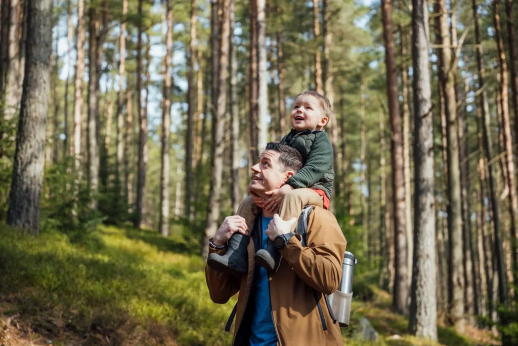 Father and young son in the woods - Enjoying their time thanks to Futures Assured with trusted expert financial advice