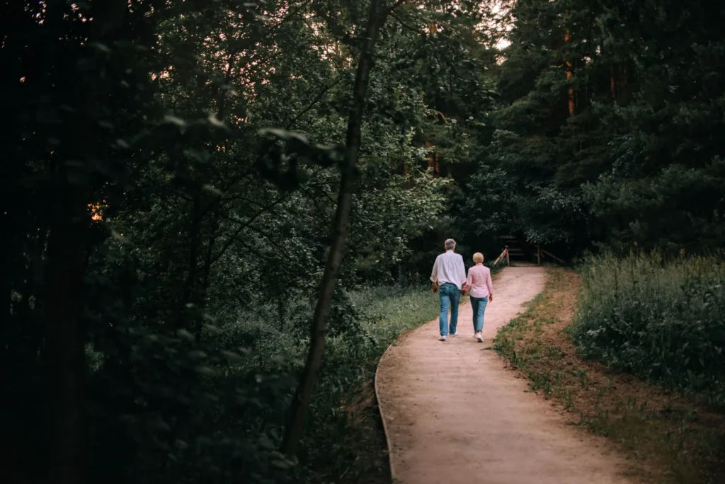 Older couple walking on a woodland path - Planning for retirement at Futures Assured with trusted expert financial advice