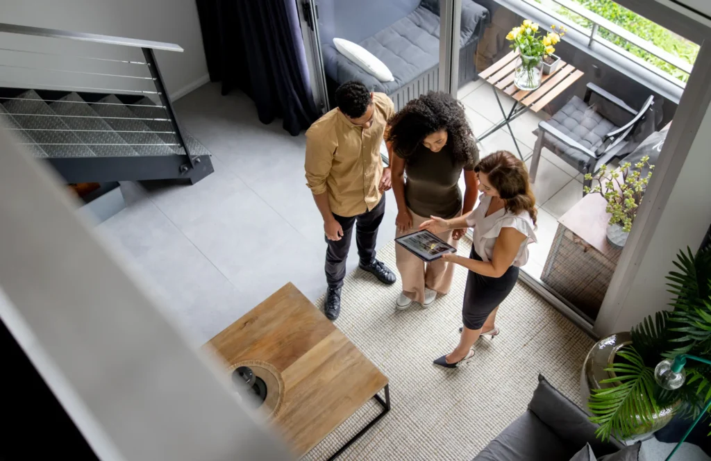 Young couple viewing a house with estate agent - Securing their mortgage at Futures Assured with trusted expert financial advice
